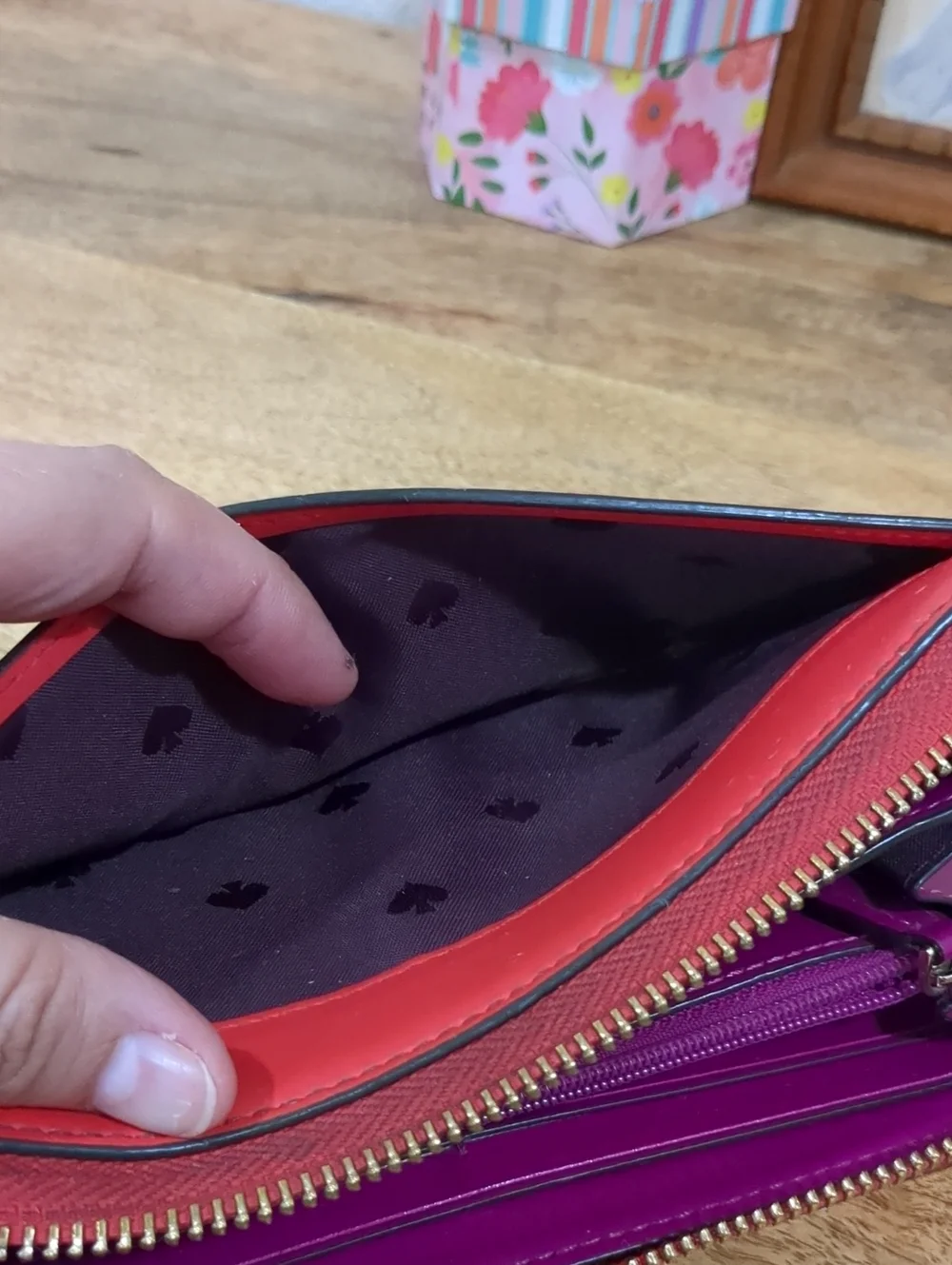 Kate Spade red zip-around wallet with Ace of Spades patch